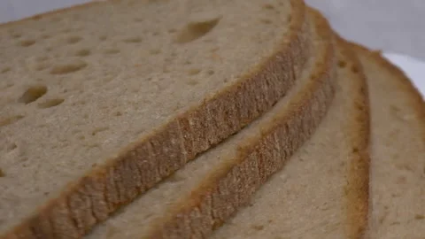 Close-up of three slices of rye bread rotating on a white plate, showcasing.. Stock Footage 340070324