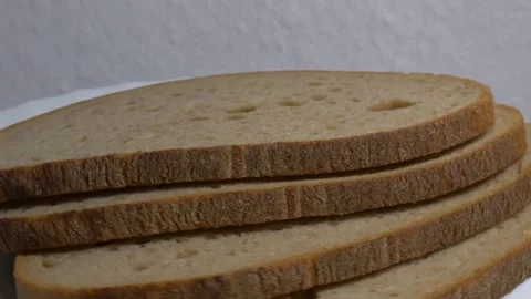 Close-up of three slices of rye bread rotating on a white plate, showcasing.. Stock Footage 340070354