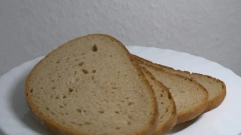 Close-up of three slices of rye bread rotating on a white plate, showcasing.. Stock Footage 340070369