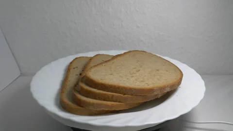 Close-up of three slices of rye bread rotating on a white plate, showcasing.. Stock Footage 340070393