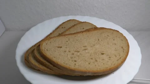 Close-up of three slices of rye bread rotating on a white plate, showcasing.. Stock Footage 340070457