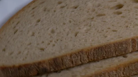 Close-up of three slices of rye bread rotating on a white plate, showcasing.. Stock Footage 340070508