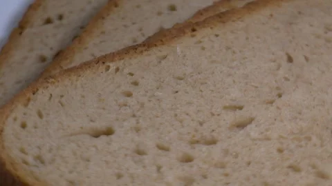 Close-up of three slices of rye bread rotating on a white plate, showcasing.. Stock Footage 340070510