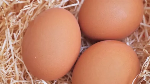 Close up of three spinning eggs on hay Video stock 228993969