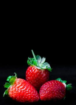 CLose-up of three strawberries on a black background Stock Photos