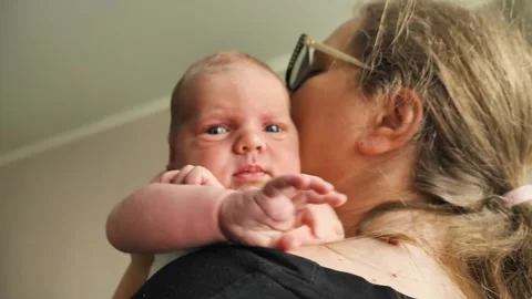 A close-up of a three-week-old baby, wide-eyed and curious Stock Footage 345554914