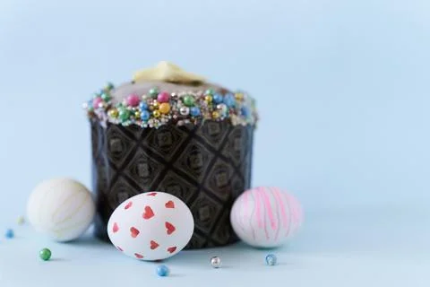 Close-up of three white Easter eggs with a pattern and one cake on a blue Fotos de archivo