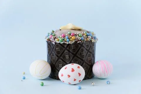 Close-up of three white Easter eggs with a pattern and one cake on a blue Fotos de archivo