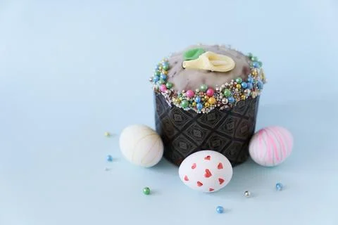 Close-up of three white Easter eggs with a pattern and one cake on a blue Fotos de archivo