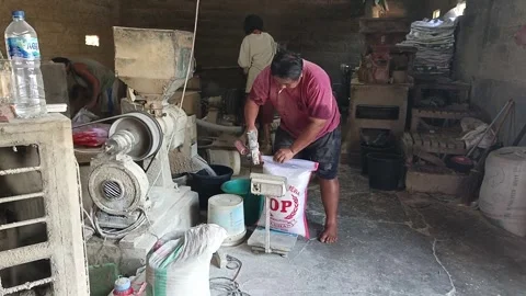 Close Up Three Workers Sewing Sacks And Packing Bran At Traditional Rice Mill Stock Footage 345502609