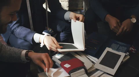 Close Up of Three Young Men Looking at Fine Fabrics for Suits Video stock 62554856