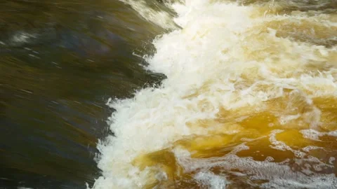 A close-up of the threshold of a mountain river with brown water. Stock Footage 332364671