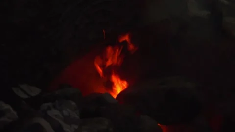 Close Up of Throwing Charcoal into a Roaring Fire Pit Stock Footage 346608827