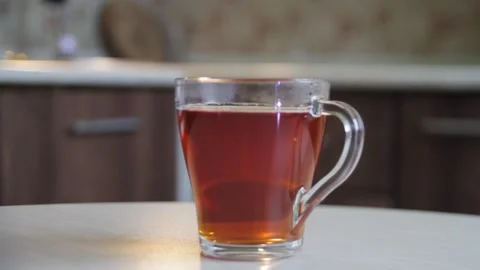Close up throwing cubes of white sugar in transparent glass cup of black tea Stock Footage 130729652