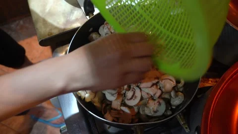 Close up throwing mushrooms into a kitchen pot to cook them Stock Footage 146002646