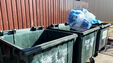 Close-up of throws a bag of garbage into a plastic tank Stock Footage 113740915