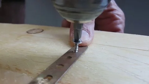Close up of thumb, electric screwdriver screws screw into metal on wooden board Vídeos de archivo 77401241