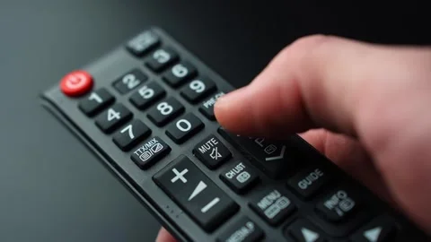 Close-up of a thumb pressing the channel up or next program control on a TV 스톡 동영상 331323840