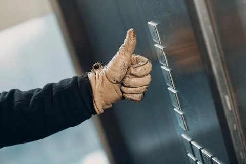 Close up of thumbs up pressing the button elevator during coronavirus pandemic Foto stock