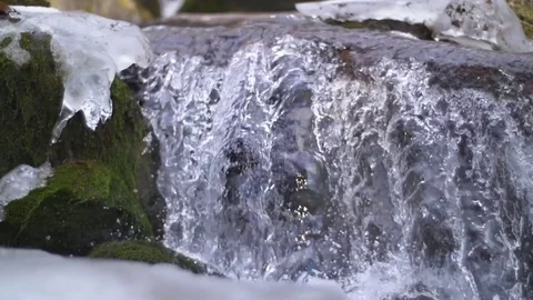 Close up tight shot of small waterfall of shallow stream in slow motion Stock Footage 85102308