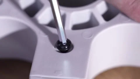 Close-up of tightening bolt with hex key during office chair base assembly Stock Footage 327910038