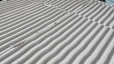 Close-up of tile adhesive combed into uniform parallel ridges, showing precise Stock Footage 345832914