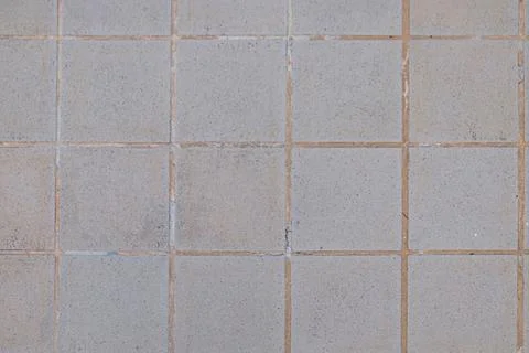 A close up of a tile floor with a white wall Stock Photos