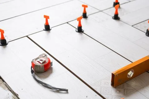 Close-up of tile leveling system during floor tiling, spacers and measureme.. Stock Photos