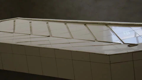 Close up of a tiled autopsy table with a raised design, paired with a sink. Vídeo Stock 299050452