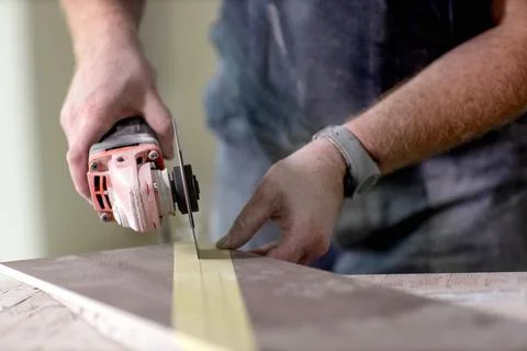 Close-up of tiler cutting ceramic tile for the floor or wall Stock Photos