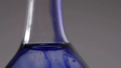 Close up tilt of a flat bottomed flask filled with blue liquid Stock Footage 231488214