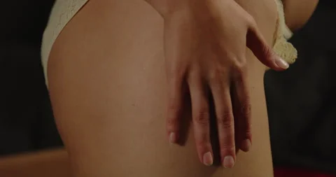 Close tilt up of a hand caressing the thigh of an woman dressed in sexy lingerie Stock Footage 282341827