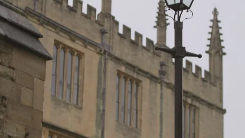 Close up tilt up view student pass with umbrella under rain by Oxford university 스톡 동영상 251053712