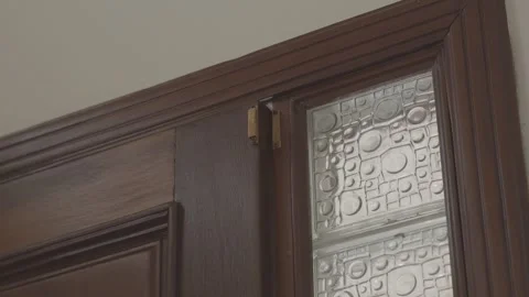 Close-up tilted shot of a rustic wooden door creaking shut, sunlight bleeding 스톡 동영상 311513584