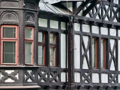 Close-up of timber-framed building facade with sash windows Stock Photos