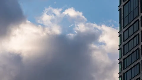 Close-up time-lapse of downtown skyscraper on sunny day, blue sky white clouds Stock Footage 319292441