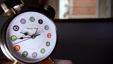 Close-Up Time-Lapse of a Silver Retro Alarm Clock by an Open Window Stock Footage 336692896