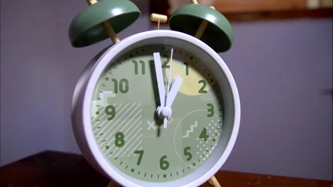 Close-Up Time-Lapse of a White Retro Alarm Clock on a Wooden Table Stock Footage 338297639
