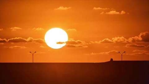 Close-up timelapse of the sun setting behind the promenade on the asturian co Stock Footage 148986704