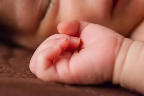 Close up of a tiny and delicate hand of a cute small two weeks old newborn Stock Photos