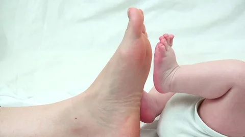 Close up to tiny baby feet step on mother big sole Stock Footage 84670613