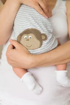 Close-up of tiny baby in socks in the hands of his mother. Stock Photos