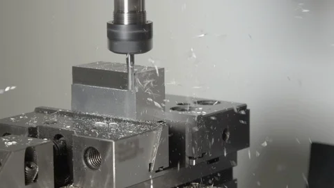 CLOSE UP: Tiny chips come flying off a small metal cube processed by lathe tool Stock Footage 113885107