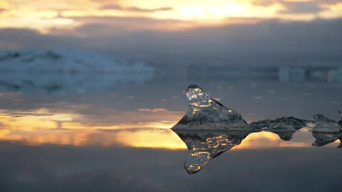 Close-up, a tiny chunk of ice flows in a lagoon at sunset, Iceland Video stock 140529937