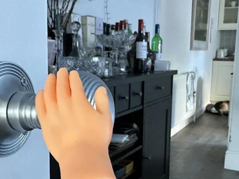 Close up of a tiny finger puppet hand opening door into living room Stock Photos