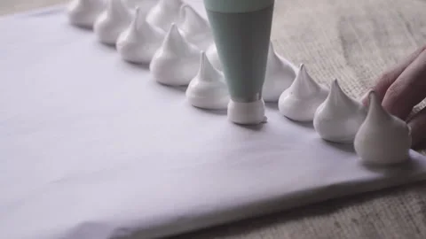 Close up on tip of pastry bag making meringues Stock Footage 240578856
