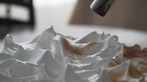 Close up on tip of pastry torch roasting meringue, natural light, slow motion Stock Footage 240936313