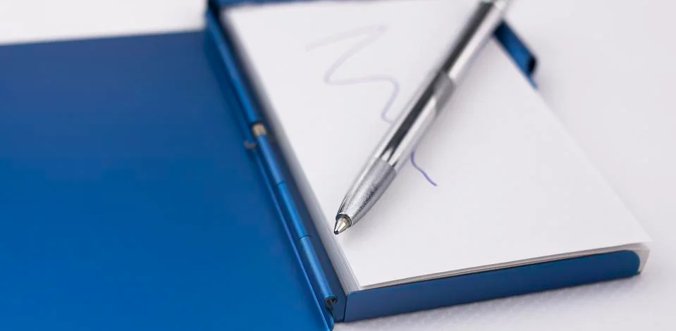 Close-up of the tip of a silver pen on a notepad to write down reminders Stock Photos