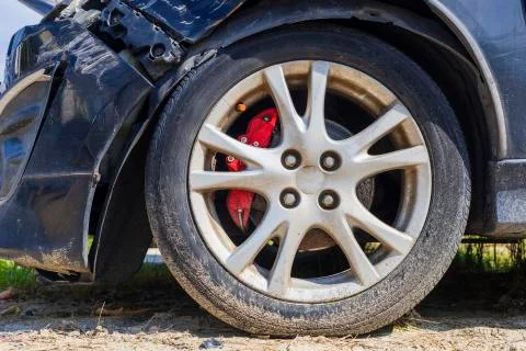 Close up tire after front black car damaged and broken by accident on road Stock Photos