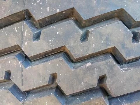 Close-up of a tire tread pattern featuring deep, angular grooves Stock Photos